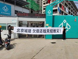 白条幅上赫然写着几个黑色的大字:北京城建 欠债还钱天经地义!