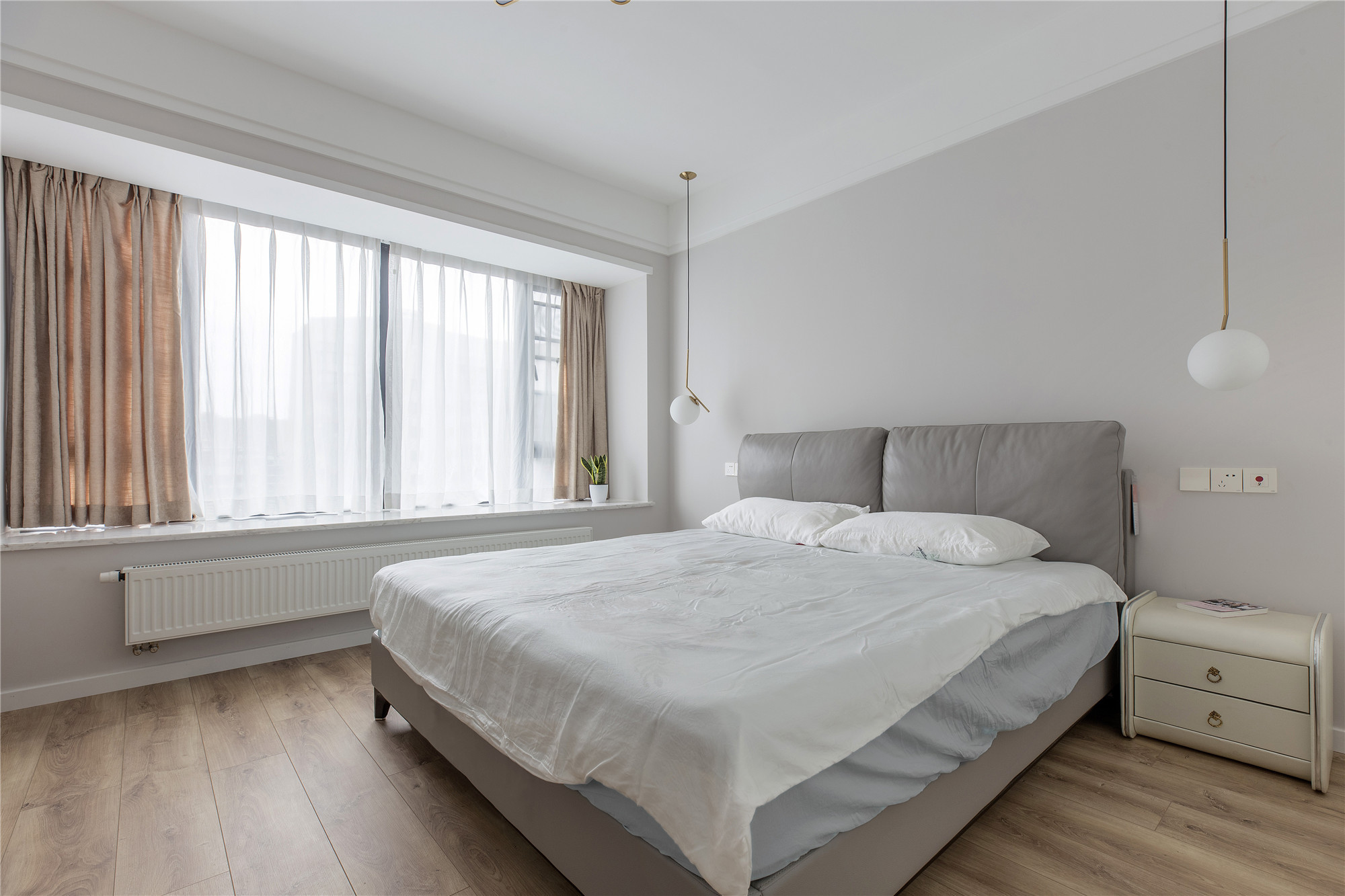卧室走的是高冷现代风,大面积白色乳胶漆墙面配上木地板,低饱和度的
