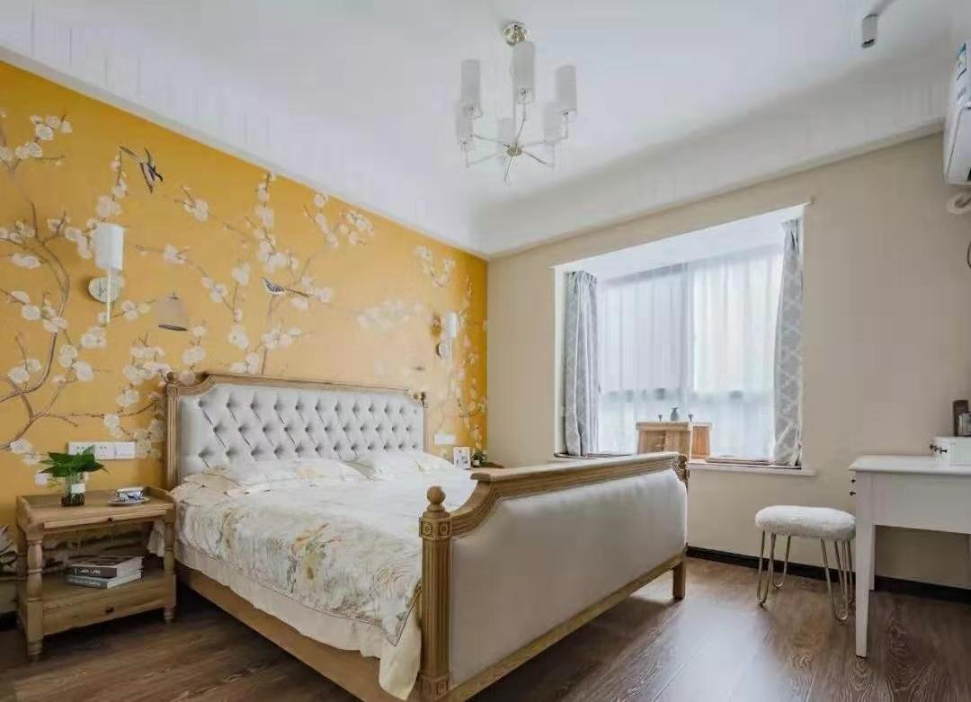 主卧的床头以黄色花鸟墙布做为背景墙.加上美式的实木床.