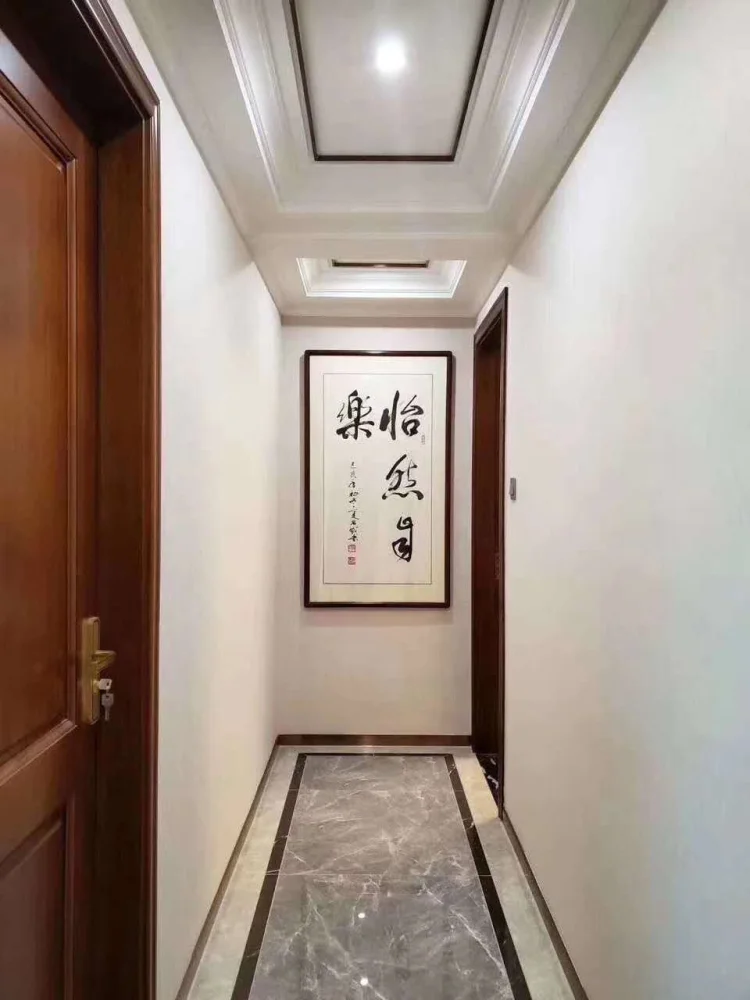 这是走廊实景拍摄,走廊尽头是一幅简单的中式字体画,简约的走廊吊顶.