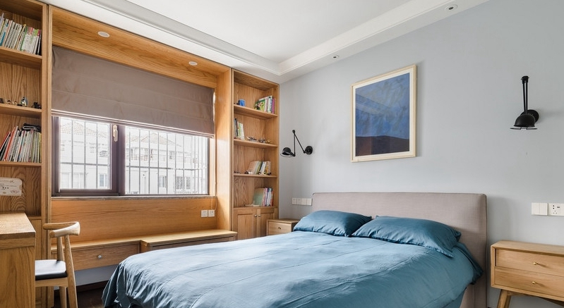 卧室木质色的储物柜靠窗设置,足够实用,搭配蓝色的床品,床头用同色系