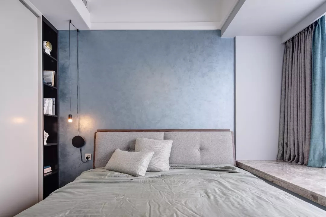 卧室整体现代简洁的空间,灰蓝色的的空间感,地面是马赛克地毯,让空间