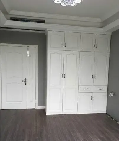 我们在每一个房间都做了衣柜,这个主卧进门的墙面做满了柜子,很大程度