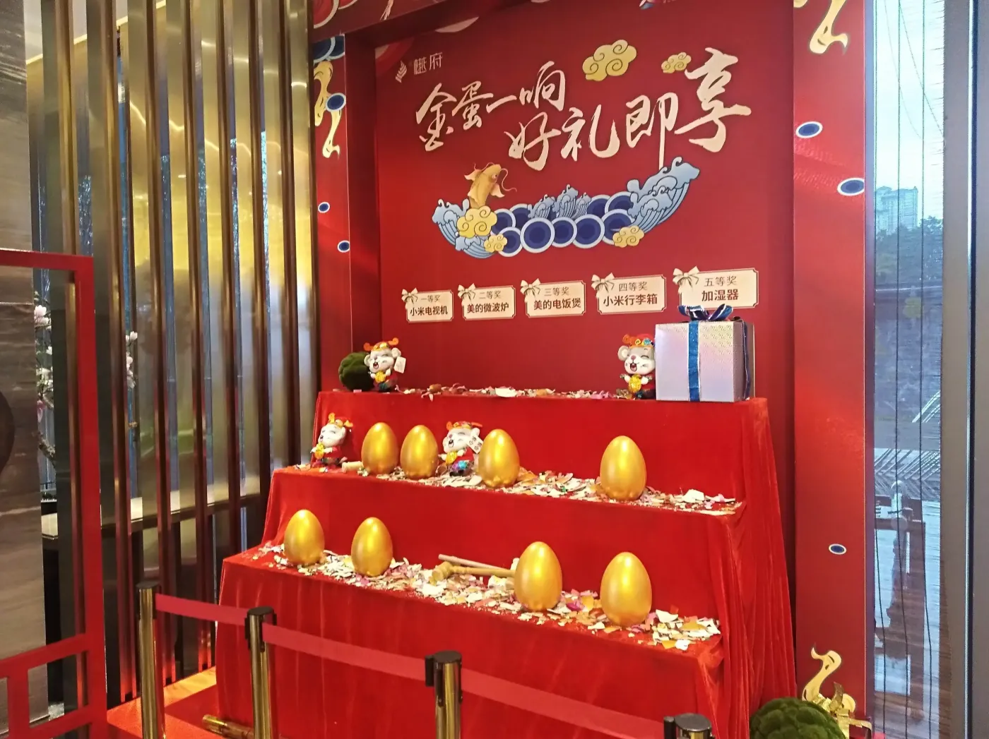 这位于大门口的抽奖台上遍地因购房者抽奖砸金蛋而产生的碎片无声宣告