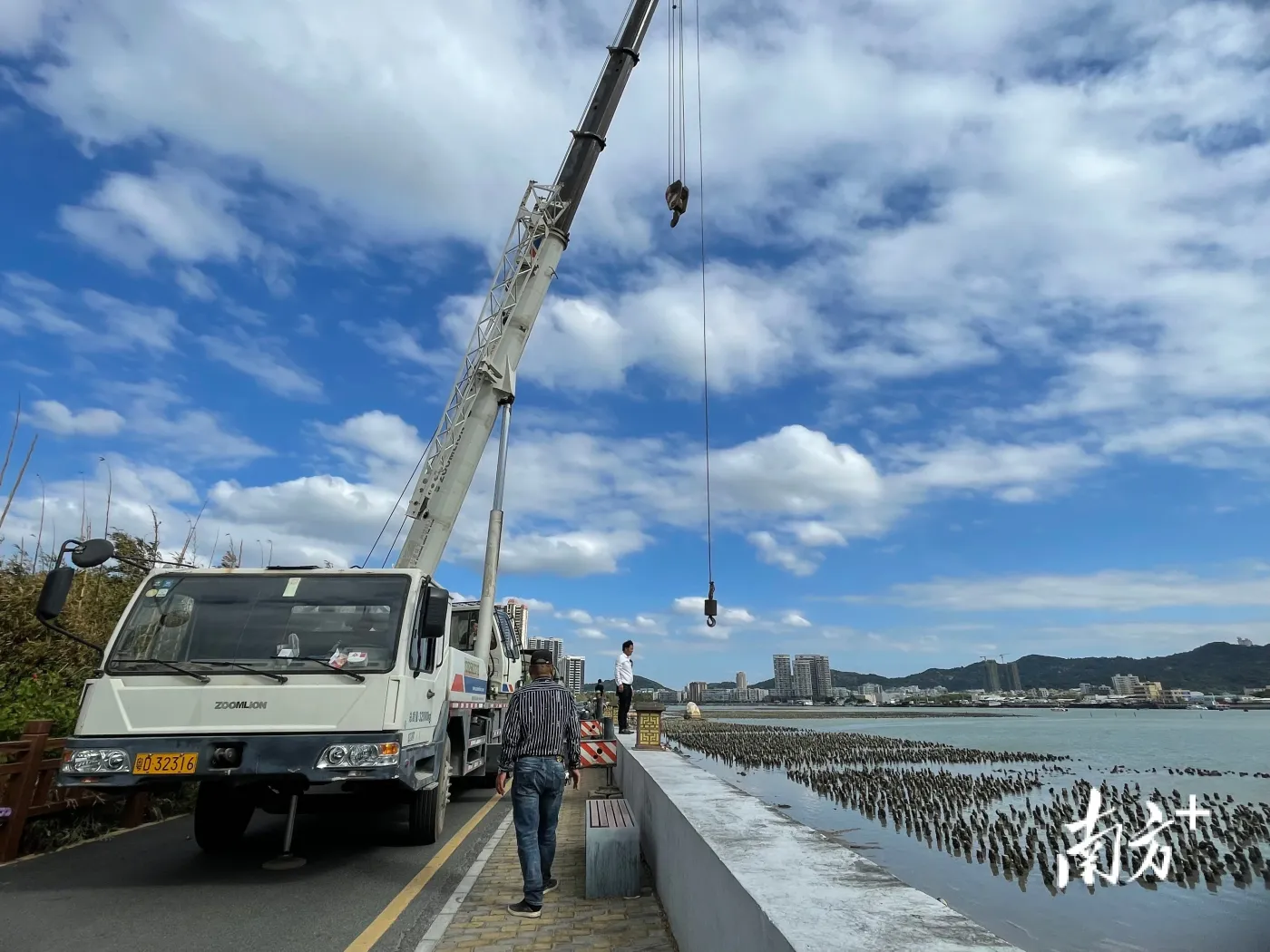 濠江区海洋综合执法大队派出执法艇协助水上巡防,2台大型吊车配合滩涂