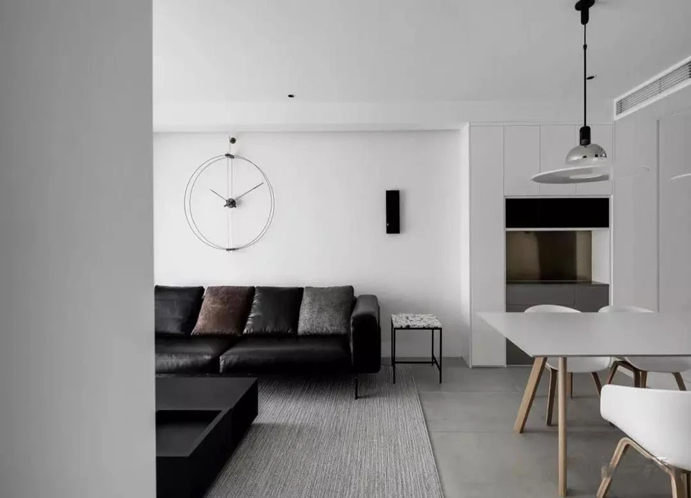 灰色皮质主沙发搭配同色系茶几,侧面顶部设计洗墙灯,增加白色空间的