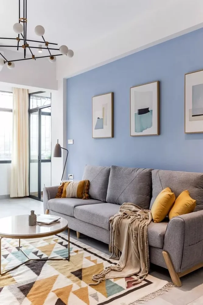 蓝色调的沙发墙,挂上几幅简约格调的装饰画,布置暖灰色布艺沙发,也